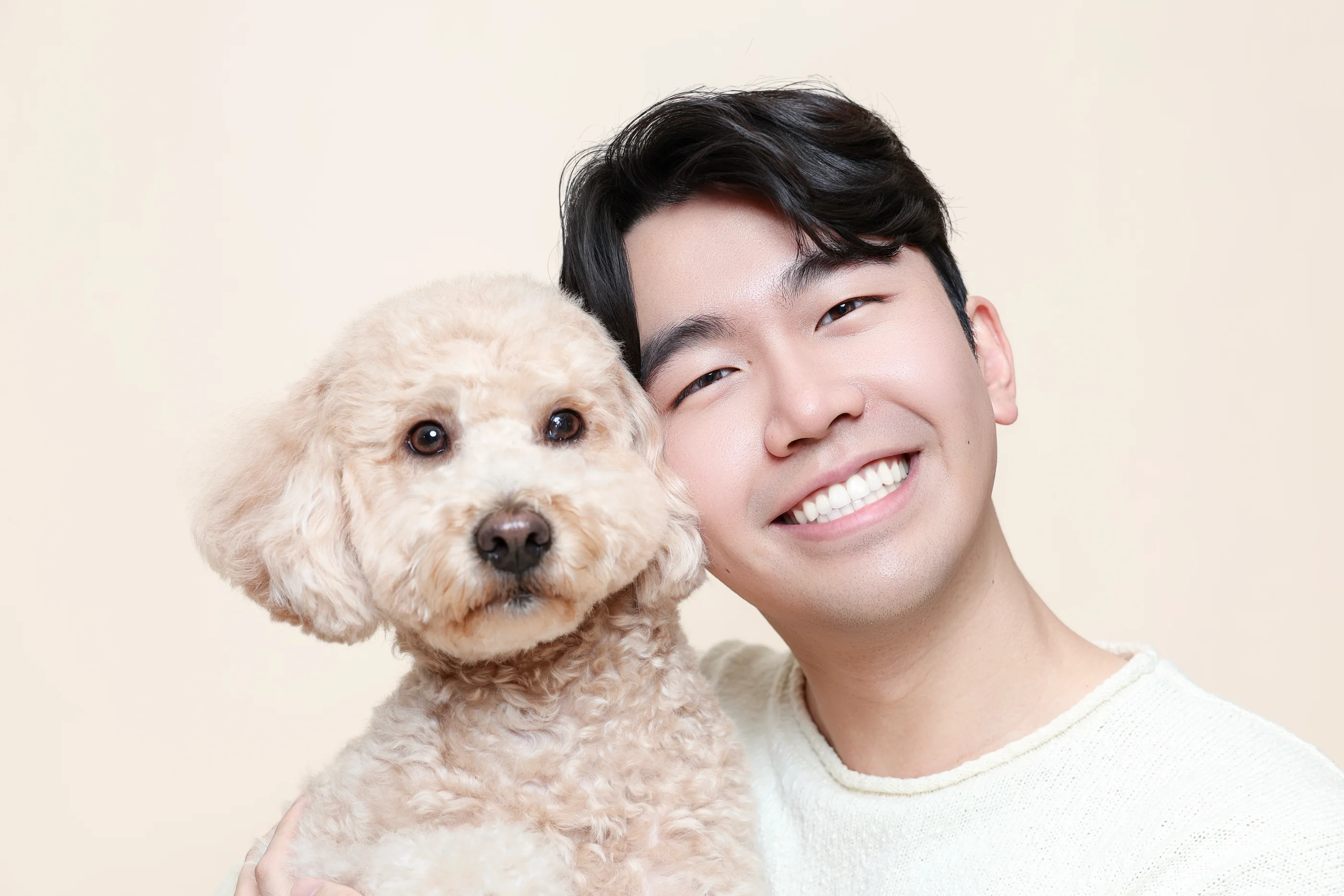 Shawn smiling beside his cream-colored dog