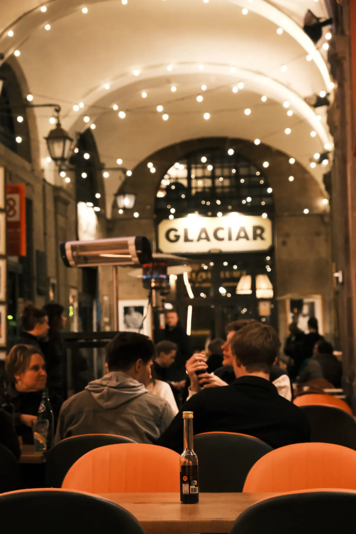 Café tables beneath glowing string lights at Glaciar on Plaça Reial