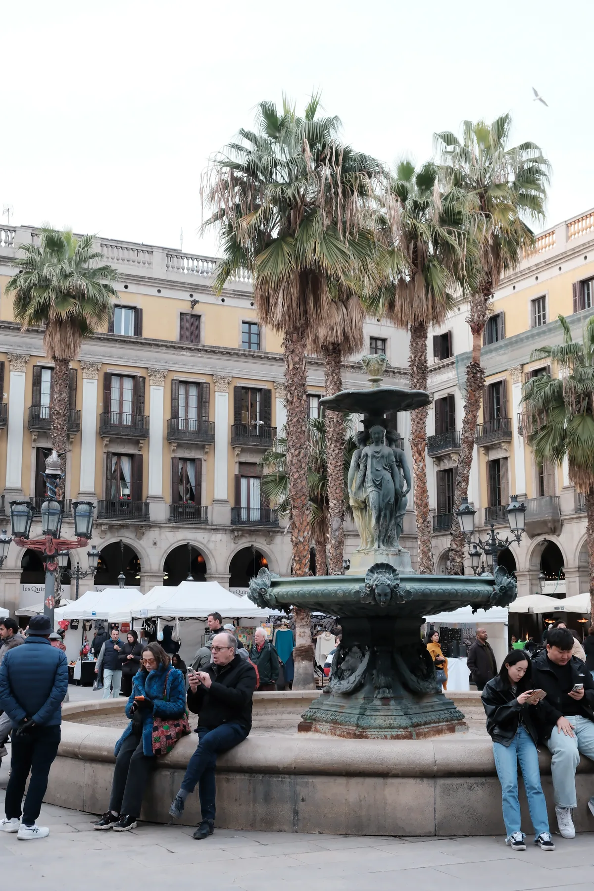 The fountain, palm trees, and surrounding arcades of Plaça Reial in Barcelona