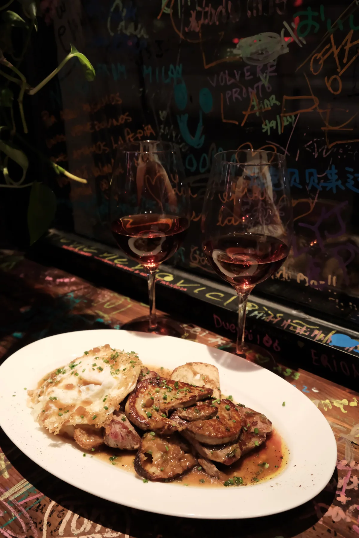 La Pepita's beef Pepita with seared foie gras, mashed potatoes, toasted bread, and two glasses of rosé