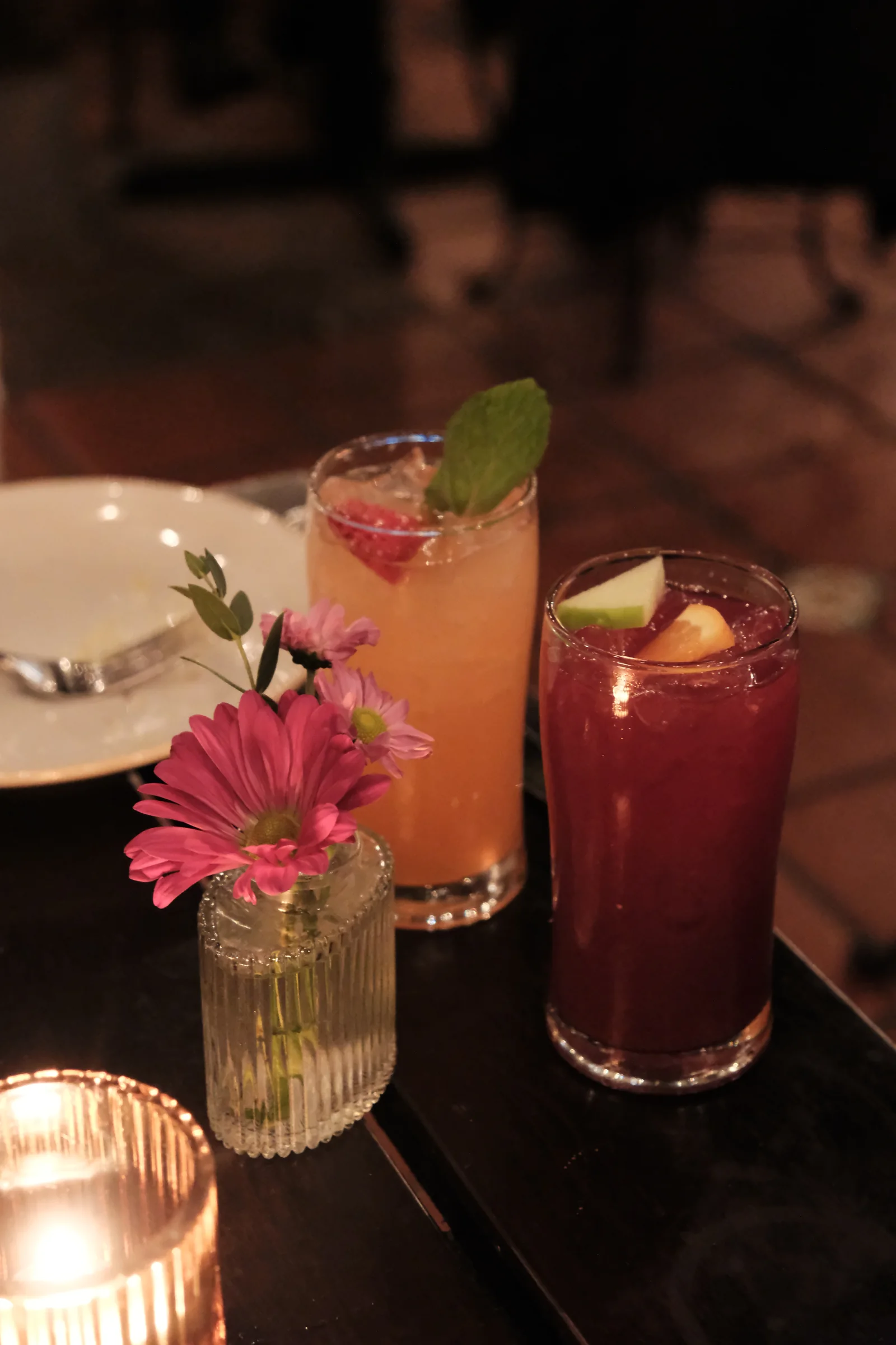 A glass of red sangria and a flower-garnished strawberry limonada