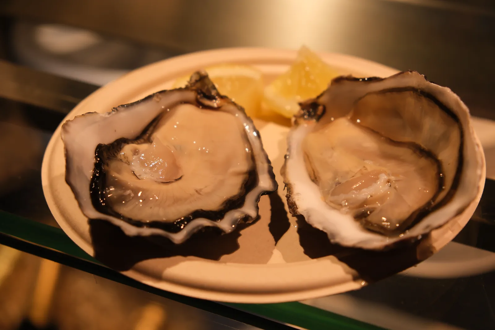 Two freshly opened oysters served with lemon at Mercado de San Miguel