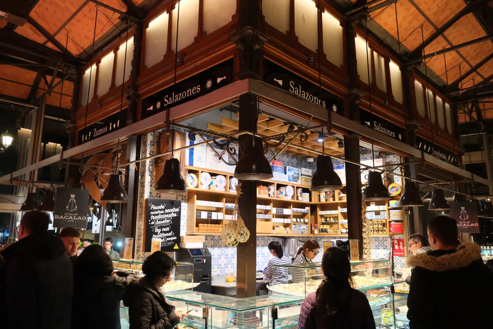 A warmly lit salted fish stall inside Mercado de San Miguel