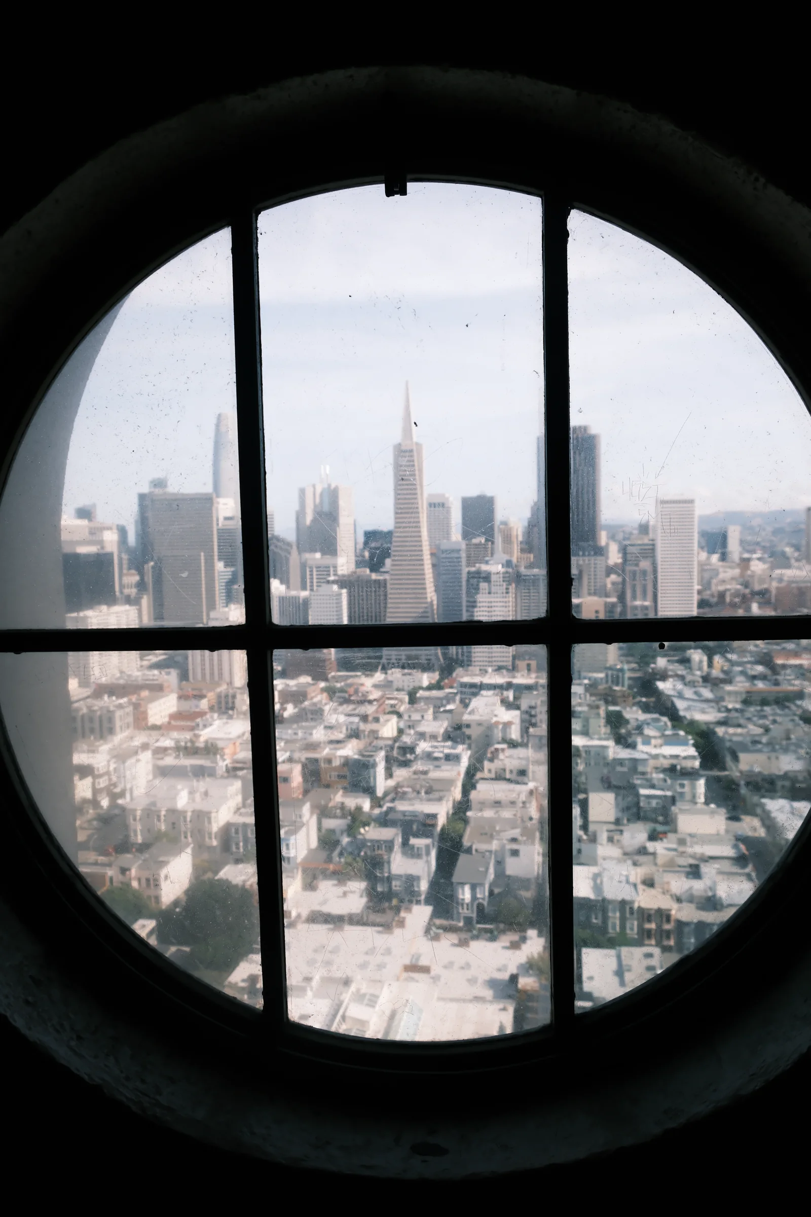 San Francisco framed through a circular window divided by dark mullions