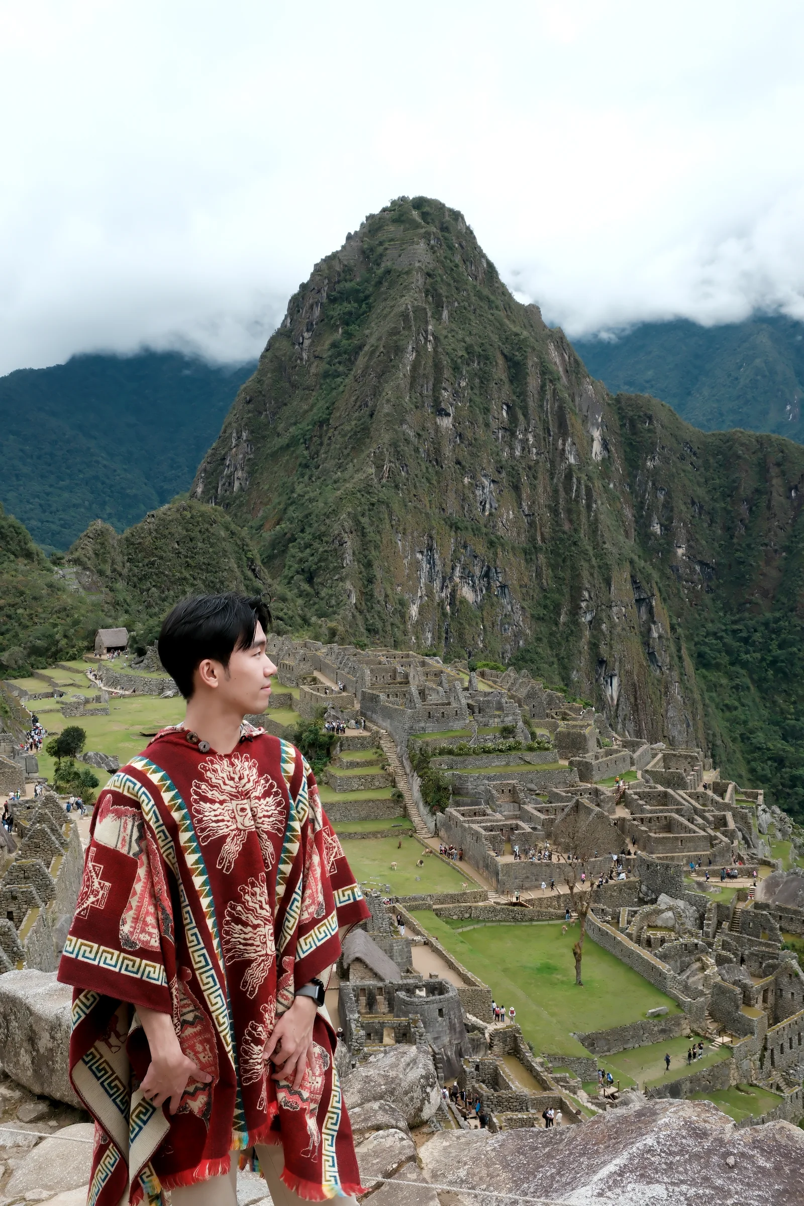 Shawn looking across the stone terraces of Machu Picchu beneath a cloud-wrapped mountain